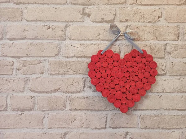 赤の心レンガの壁にかかっている 愛の文字が刻まれています 軽いレンガの壁に手作りの心 コピースペース バレンタインデーへの贈り物 2つの形の心は古いレンガの壁にかかっている 恋人のシンボル — ストック写真
