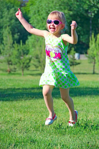 快乐的小女孩在城市公园里奔跑 积极的孩子气排放 孩子们沿着小路跑来跑去 高兴着 快乐的童年小女孩沿着城市公园跑着 — 图库照片