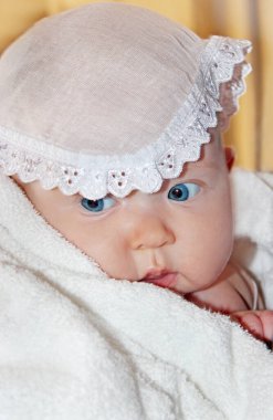 Yeni doğmuş bebek vaftiz havlusuyla örtülmüş. Çocuksu bir yüz. Vaftiz sırasında çocuk. Dantelli bebek