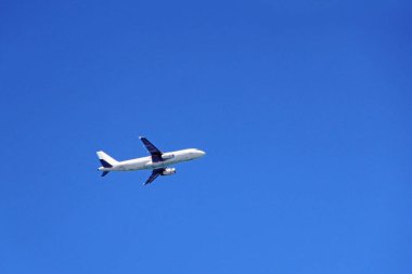 Uçak gökyüzünde yüksekten uçuyor. Mavi gökyüzünde uçan hava aracına bakın. Mavi gökyüzünde bir uçak görüldü. Bulutsuz gökyüzünde uçaklı hava manzarası. Uçan hava gemisi