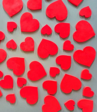 Duvarda asılı kırmızı kalpler. Aşkın dokulu sembolü. Duvarda kırmızı kalpler var. Sevgililer Günü hediyesi. Duvarda şekilli kalpler asılı. iç tasarım