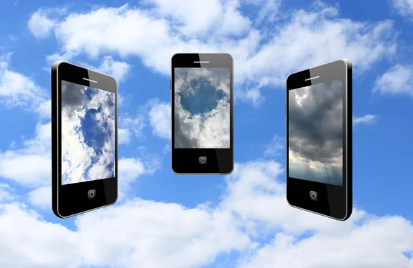 Tři moderní mobilní telefony na zatažené obloze — Stock fotografie
