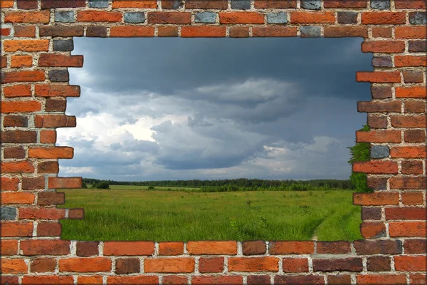 Parede de tijolo quebrado e vista para o campo com trovão — Fotografia de Stock