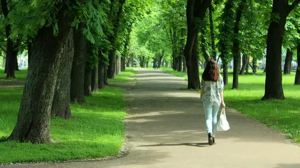 Młodych kobiet chodzących na piękny park z drzewami — Zdjęcie stockowe