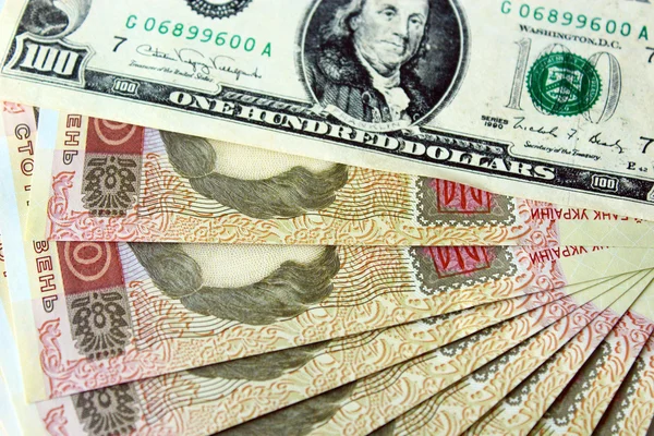 Koyu arka plan üzerinde izole 100 dolar ve grivnas banknotlar — Stok fotoğraf