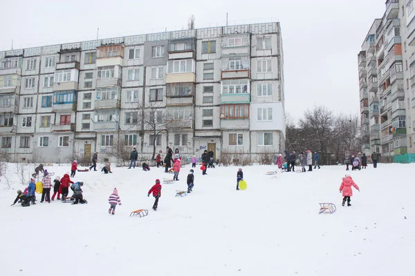 Дети катаются на санках с холма — стоковое фото