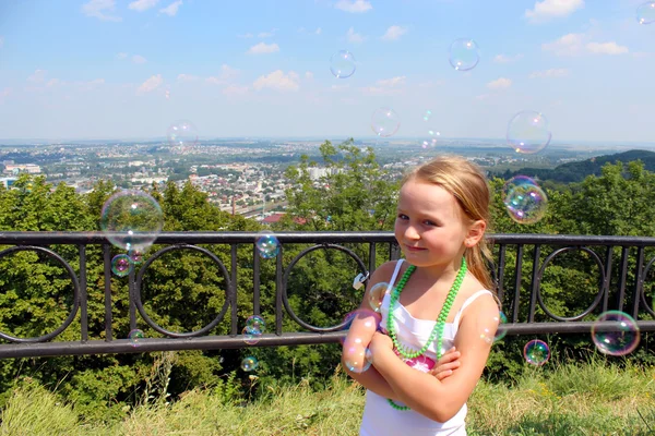 Bambina con bolle di sapone fuori città — Foto Stock