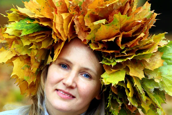 Femme avec des feuilles jaunes sur la tête — Photo
