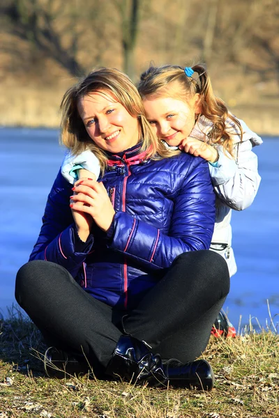 Madre y su hija abrazan y sonríen —  Fotos de Stock