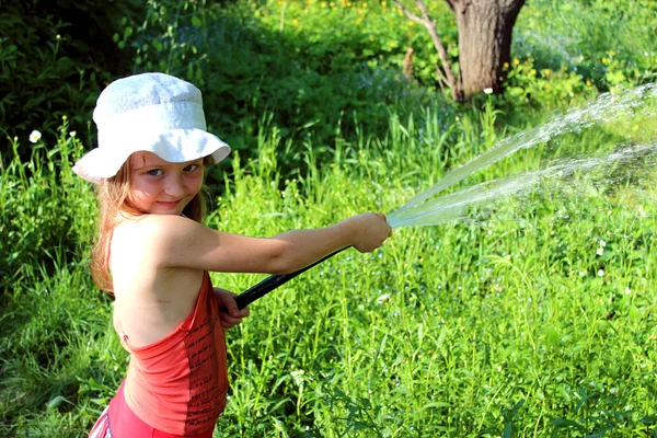 Menina molhando um jardim de cozinha — Fotografia de Stock