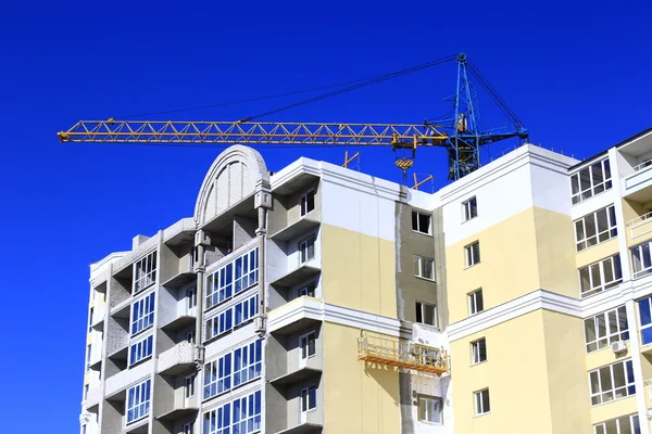 Bau eines mehrstöckigen modernen Hauses mit Hubkran — Stockfoto