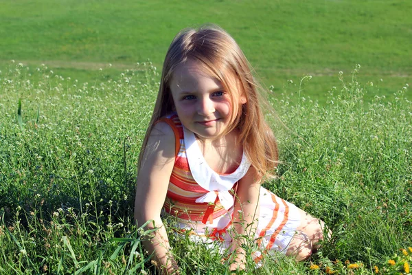 Porträtt av lilla flickan liggande i gräset — Stockfoto