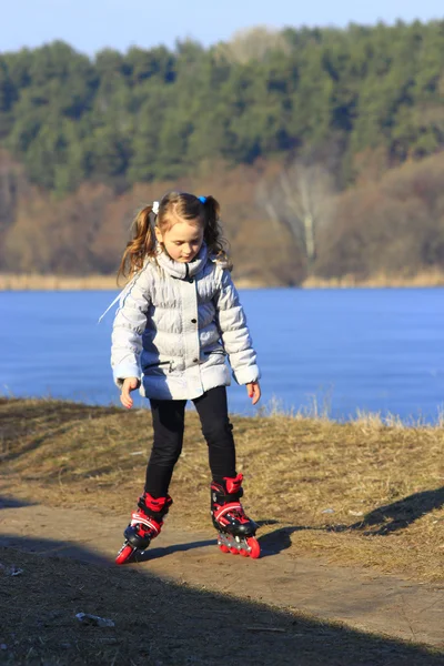 Jeune fille va en patins à roulettes sur le sol — Photo