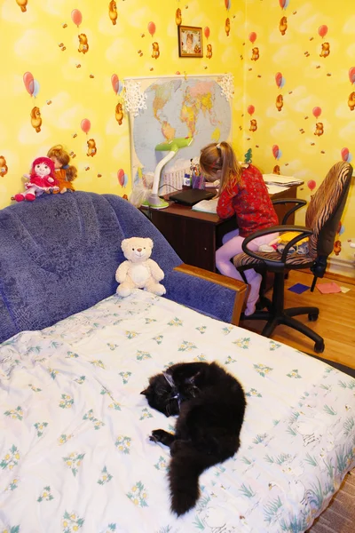 Black cat sleeping on the bed in childrens room — Stock Photo, Image