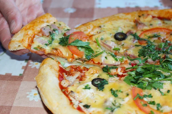 Man tar en bit av välsmakande pizza från plattan — Stockfoto