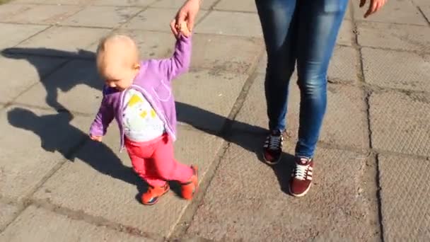 Счастливая мать со своей маленькой дочерью идут вручную — стоковое видео