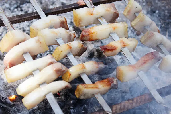 Trozos fritos de manteca de cerdo cocinando en el fuego — Foto de Stock