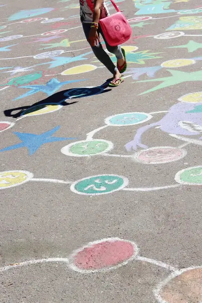 Asfalt üzerinde çocuksu çizimler üzerinde atlama çocuk — Stok fotoğraf