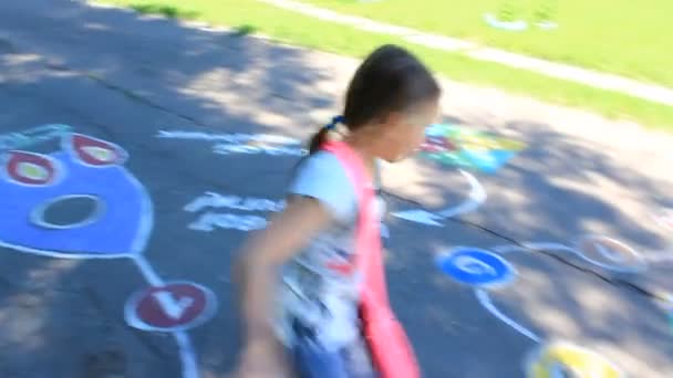 Mädchen läuft auf den kindlichen Zeichnungen auf dem Asphalt — Stockvideo