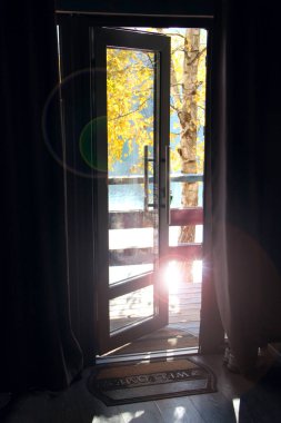 Sonbaharda göle açılan açık bir kapı. Oda tasarımı. Oda havalandırması. Kapıdan doğanın görüntüsü.
