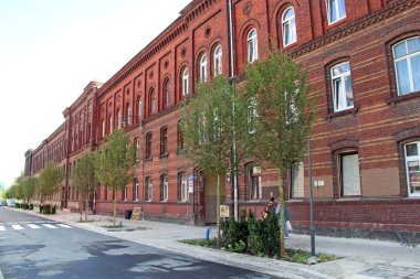 Lodz - Polonya. 18 Haziran 2019: Birçok pencereli bina. Şehir manzarası. Şehir hayatı. Pencereli eski bir kırmızı tuğla bina. Şehir binasında birçok eşit pencere