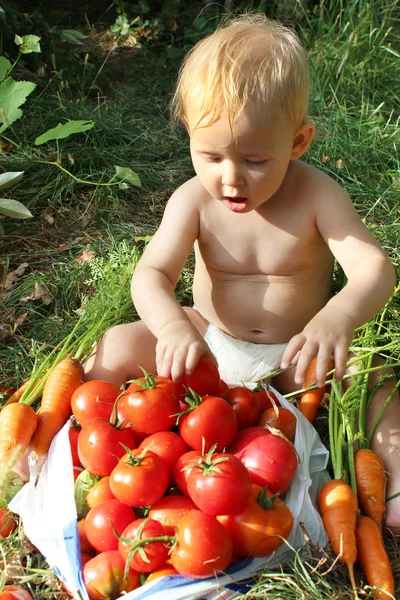 Bebê come tomates maduros — Fotografia de Stock