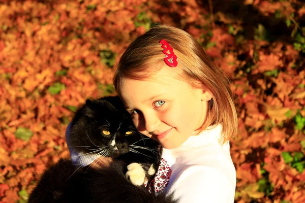 Ragazza abbracciando con il suo gatto in autunno — Foto Stock