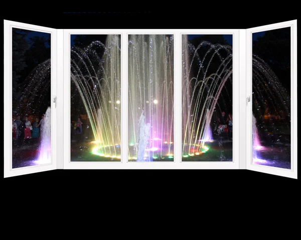 Window overlooking the colored fountains in city park — Stock Photo, Image
