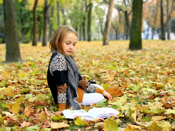 Młoda dziewczyna czyta książkę w parku jesień — Zdjęcie stockowe