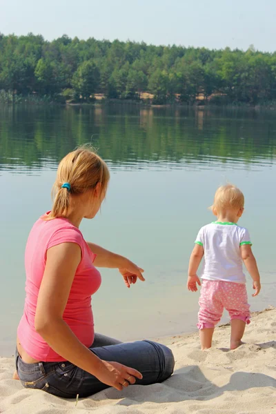 Madre guarda il suo bambino al fiume — Foto Stock