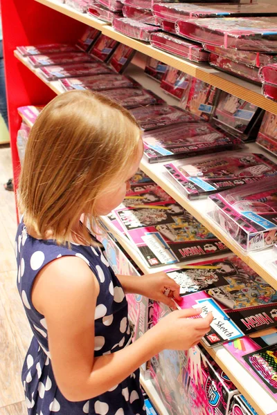 Lány úgy dönt, egy könyvet a könyvesbolt — Stock Fotó