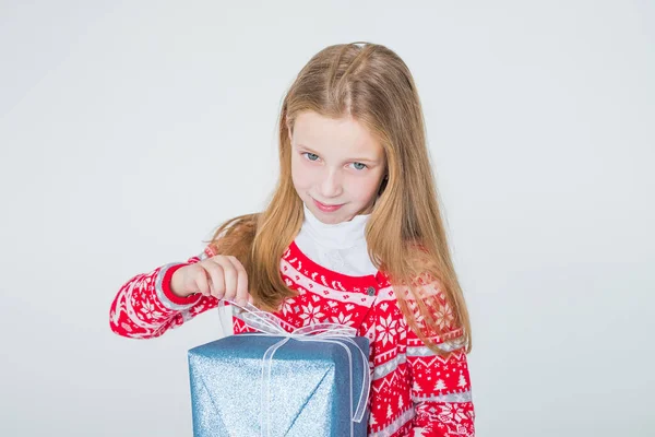 Glad liten flicka med långt hår öppen låda med jul närvarande, isolerad på vit bakgrund.Glada vacker flicka som håller gåva med båge i händerna och leende.Kopiera utrymme — Stockfoto