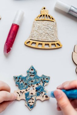 El yapımı Noel süslemeleri. Çocuklar Noel ağacı ya da hediyeler için dekor yapıyor. Noel el yapımı Diy Projesi. Sıfır atık kavram. Tahta Noel oyuncakları.