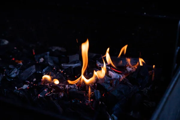 Grill de charbon de bois de barbecue chaud vide flamboyant avec des charbons lumineux sur fond noir.Danse de la flamme, barbecue sur un feu ouvert.Bois brûlant. cheminée. Préparation barbecue — Photo