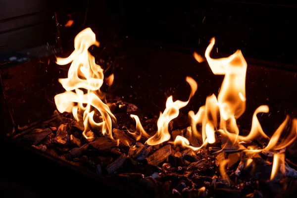 Grill de charbon de bois de barbecue chaud vide flamboyant avec des charbons lumineux sur fond noir.Danse de la flamme, barbecue sur un feu ouvert.Bois brûlant. cheminée. Préparation barbecue — Photo