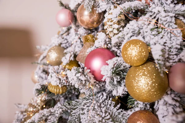 Albero di Natale decorato con giocattoli in oro e colore rosa. Ornamenti natalizi, nastri, cervi bastone figura, perline e luci ghirlanda incandescente. Inverno Holiday.Luxury arredamento nuovo anno. — Foto Stock