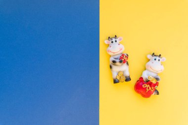 Renkli arkaplan üzerine yeni yıl dekorasyonu için boğa heykeli. Mavi sarı kağıtta öküz seramik heykeli. 2021 Çin burcunun sembolü. Uzayı kopyala