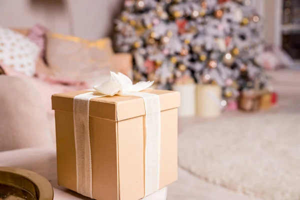 Regalos y cajas de regalo bajo el árbol de Navidad. Cajas beige con lazo de cinta. Año nuevo decorado interior de la casa. Invierno vacaciones concept.decorated árbol de Navidad con luces y un montón de cajas de regalo —  Fotos de Stock