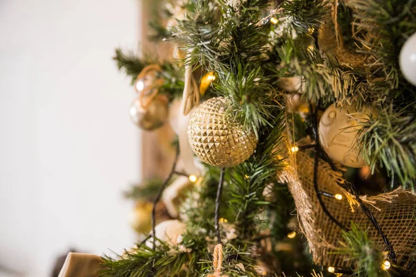 De árvore de natal decorada com pérola, prata, cristal, bolas de ouro e brinquedos com parede branca. Conceito de cartão de Natal. Conteúdo do blog.Bolas douradas e brancas. Decoração de Ano Novo Durante as férias de inverno — Fotografia de Stock