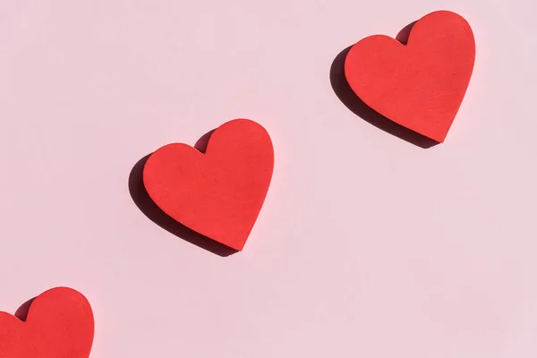 Coeurs rouges sur fond rose. Vue de dessus. Saint Valentin. Symbole d'amour. Joyeux anniversaire de la Saint-Valentin, Fête des Mères, 8 mars, concept de carte de vacances pour la Journée mondiale de la femme. Pose plate. — Photo