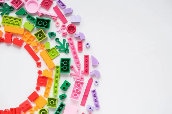 Developing children games frame. Colorful plastic bricks and blocks on white background ,top view ,space for text. Educational toy for children.