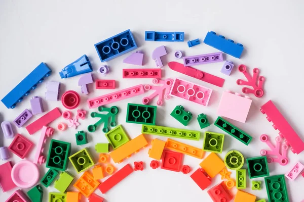 Desenvolvimento de crianças moldura jogos. Tijolos de plástico coloridos e blocos sobre fundo branco, vista superior, espaço para texto. Brinquedo educativo para crianças. — Fotografia de Stock