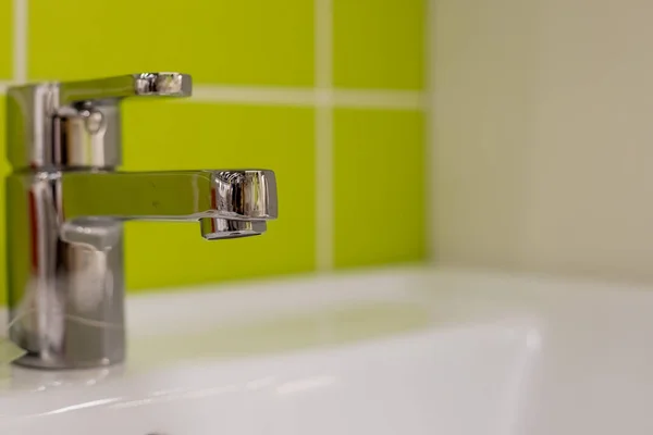 Banyo içi beyaz lavabo ve muslukla dolu. Krom banyo musluğu. Modern tasarım. Zarif banyoda lavabonun ayrıntıları. Musluk suyu. — Stok fotoğraf