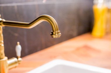 Modern bir mutfakta musluk ve lavabo. Modern bir dairede mutfak lavabosu ve su musluğu. Ev aletleri. Altın metal musluk.