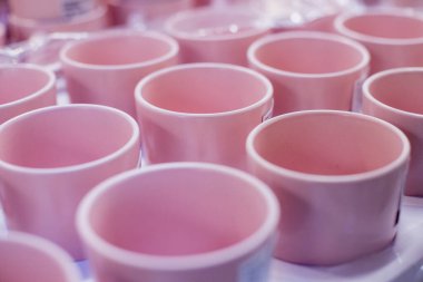 Boş seramik fincanların arkaplanı. Mağazanın raflarında beyaz ve mavi bardaklar. Kahve bağımlılığı ve çanak çömlek ürünleri kavramı.