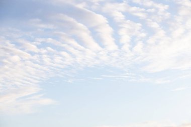 Bulutların arasından ışık huzmesi. Mavi gökyüzü, hava, atmosfer konsepti. Mavi gökyüzü arkaplan desenine karşı Cirrocumulus bulutları.