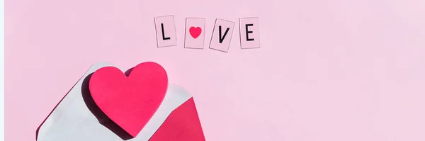 Valentijnsdag compositie met tekst LIEFDE en hartjes op roze achtergrond.Boodschap met rood hart en letters Ik hou van je, romantiek symbol.Web banner. Kopieerruimte — Stockfoto