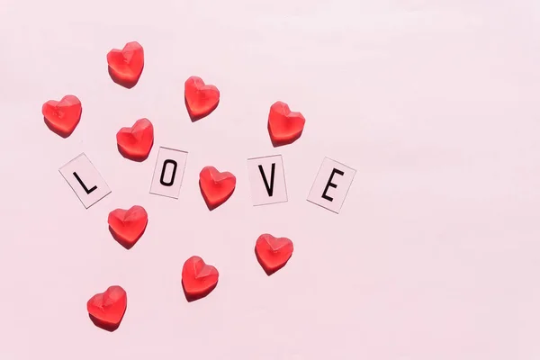 Banner.A szó Szerelem.Fekete betűk Szerelem vörös szívekkel.rózsaszín háttérre.Valentin nap. Szerető, pozitív érzelmek. Érzések háttere. Kizárólagos kapcsolatok. — Stock Fotó