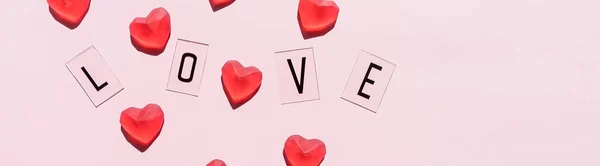 Banner.Het woord Love.Black letters Liefde met rode harten.op roze achtergrond.Valentijnsdag. Liefdevolle, positieve emoties. Gevoelens op de achtergrond. Exclusieve relaties. — Stockfoto