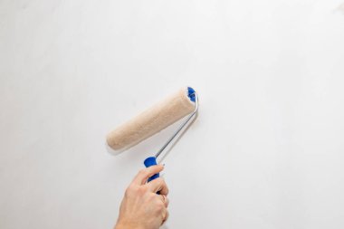 Dairesinde boyalı paten duvarı olan işçinin eli. Evdeki Tamir. Onarım ve bakım konsepti. Boşluğu kopyala